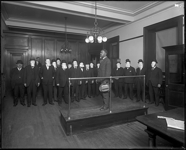 Z9.584.PP8Detective room, Police Department [African American man being watched by men wearing masks]ca. 19108 x 10 inch glass negativeHughes CompanyHughes Company Collection, ca. 1910-1946