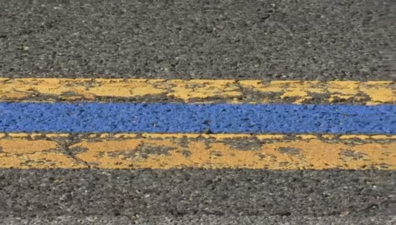 blue line between yellow lines on road